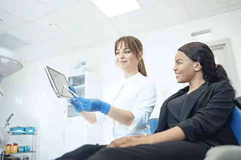 Dentist Showing Patient Tablet